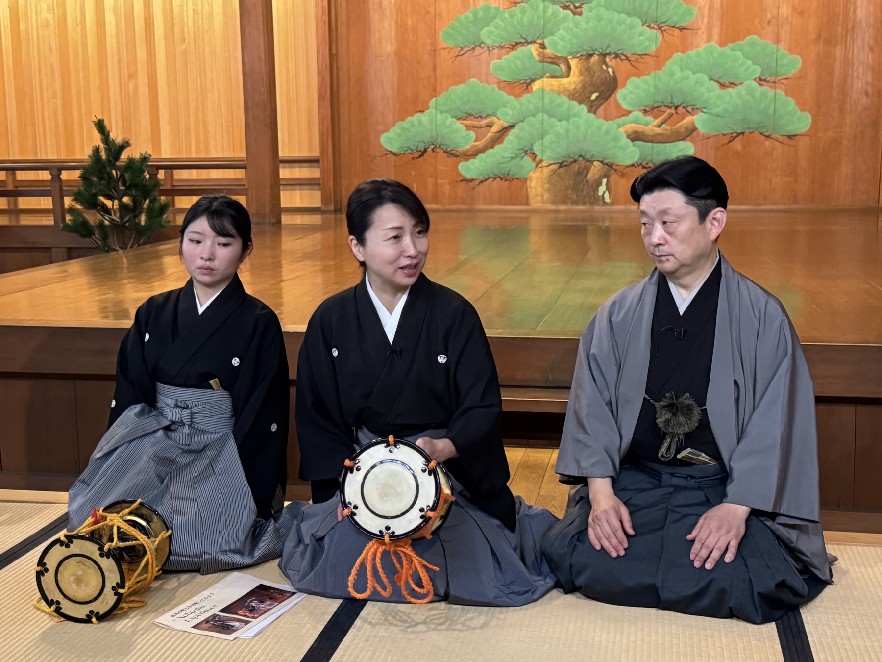 能舞台で小鼓を手にする能楽師たち